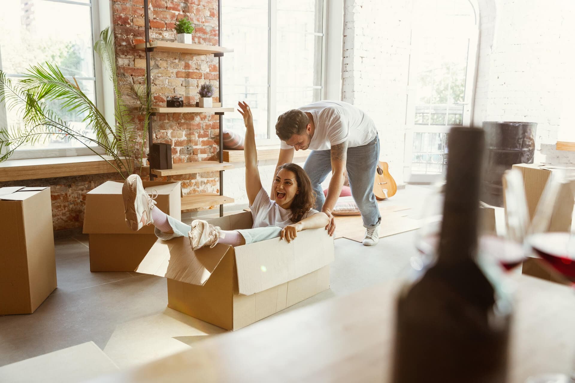 Imagem de um casal se divertindo em seu novo apartamento.